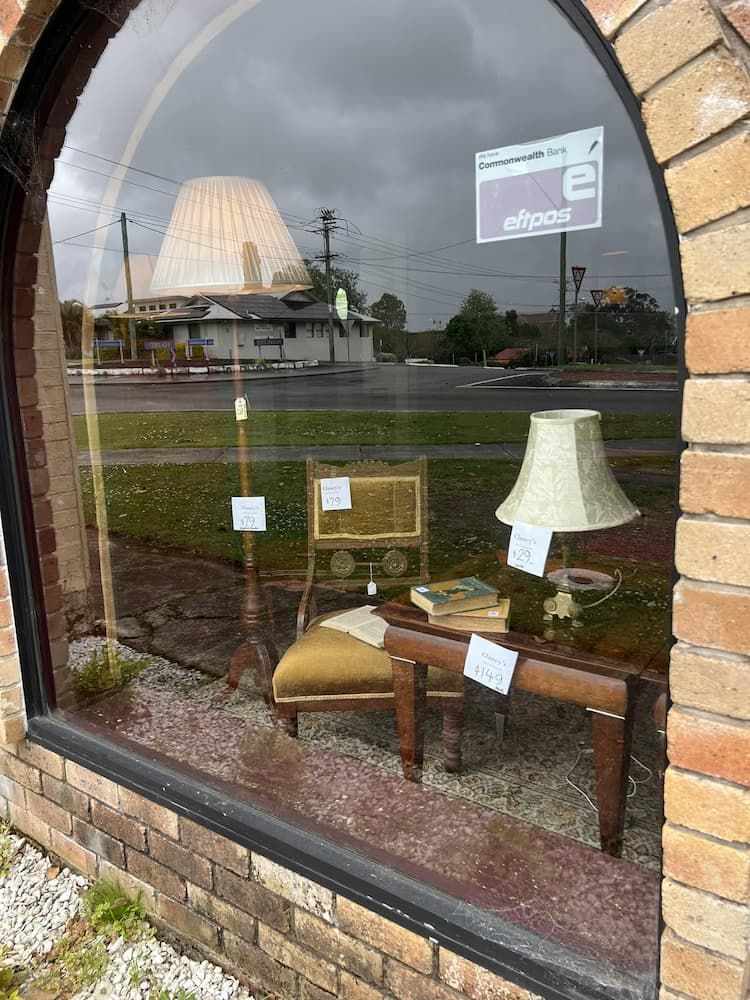 View Through a Shop Window Showcasing Vintage Furniture — Clancy's Office And  Emporium in Taree, NSW