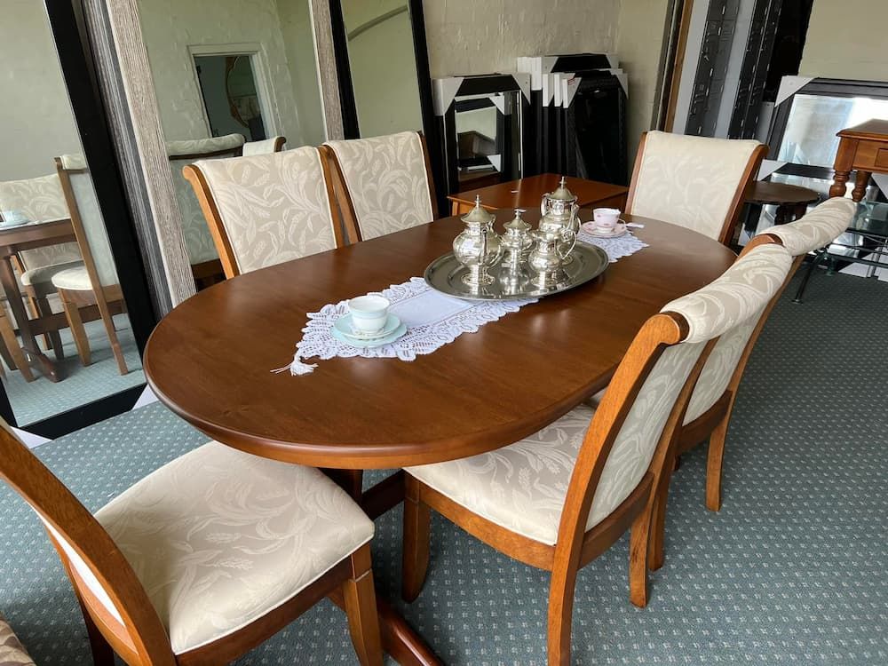 A Wooden Oval Dining Table With Six Cream-coloured Upholstered Chairs — Clancy's Office And  Emporium in Taree, NSW