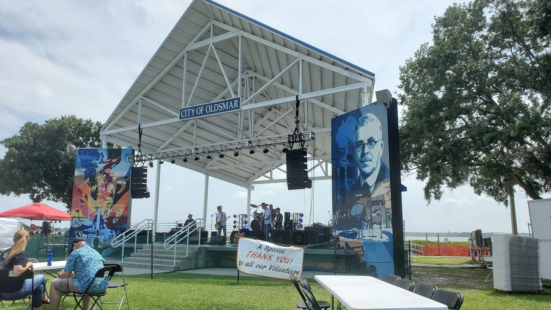A group of people are sitting in front of a large stage.