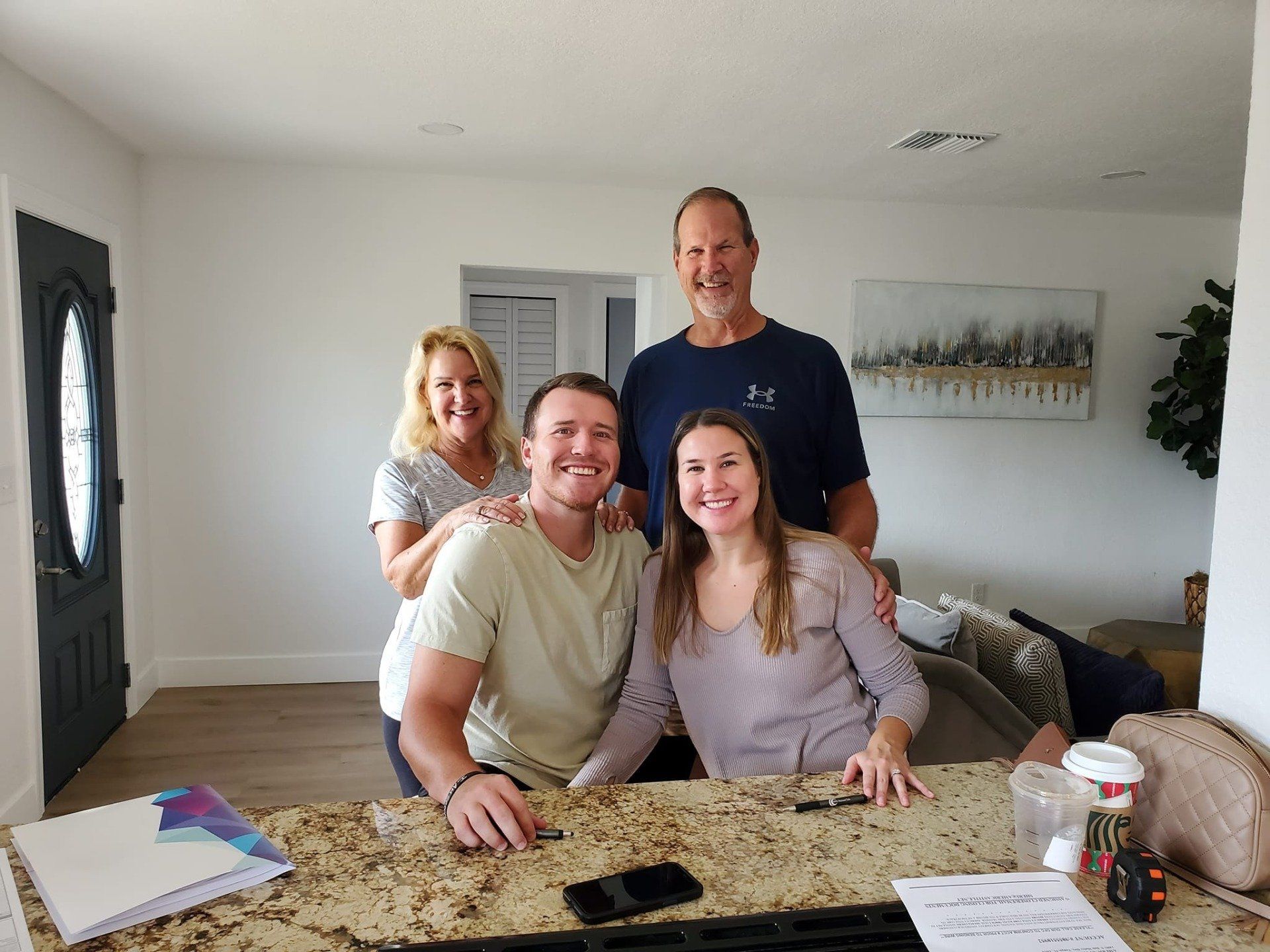 A family is posing for a picture in their new home.