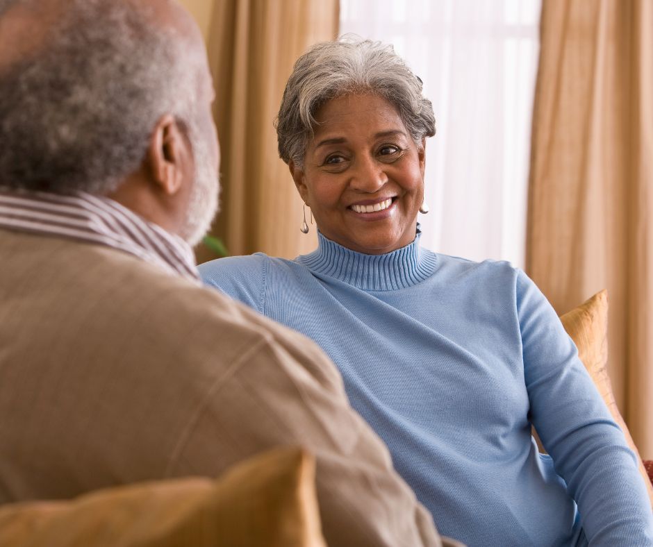 A man and a woman are sitting on a couch and smiling