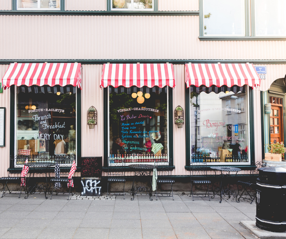 A restaurant with red and white striped awnings on the windows