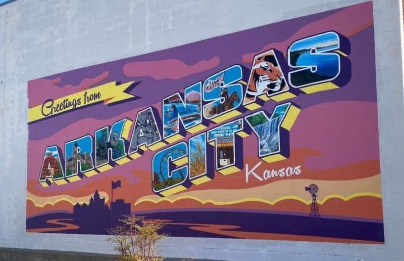 A mural on a wall in downtown Ark City that says arkansas city kansas