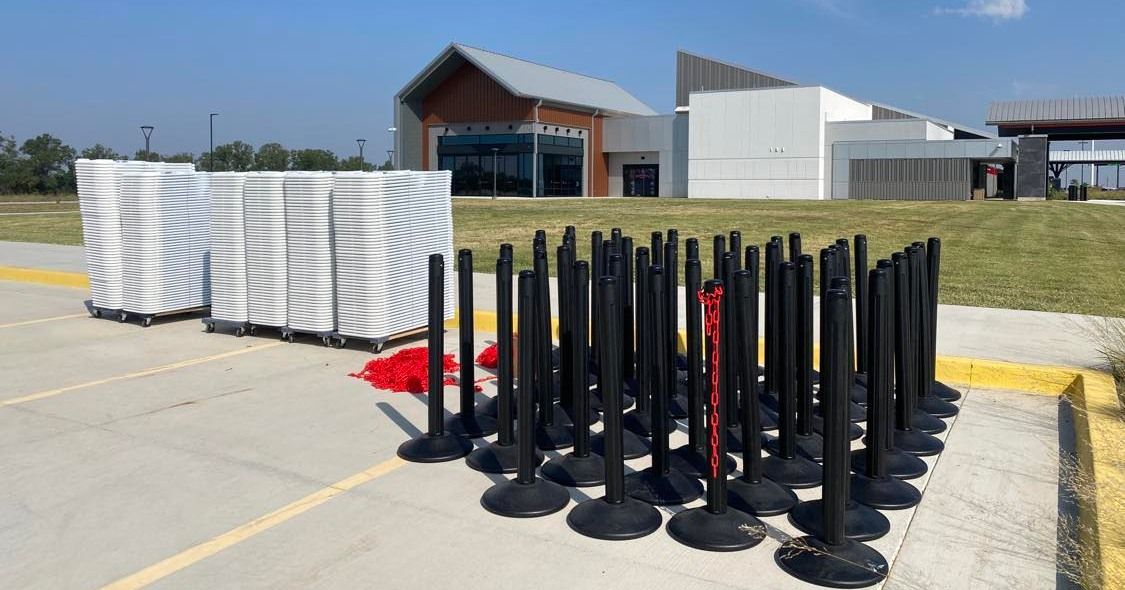 a bunch of black barriers are sitting in a parking lot in front of a building .