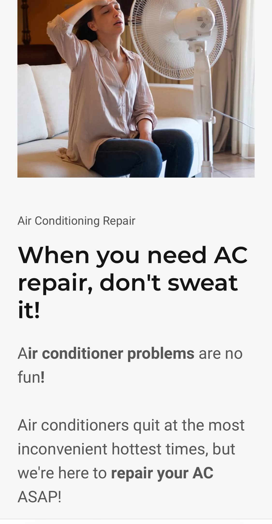 A woman is sitting on a couch in front of a fan.