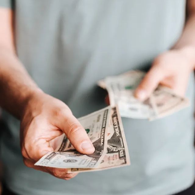 What do Google ads cost? Cost to run Google ads phot of man handing out cash
