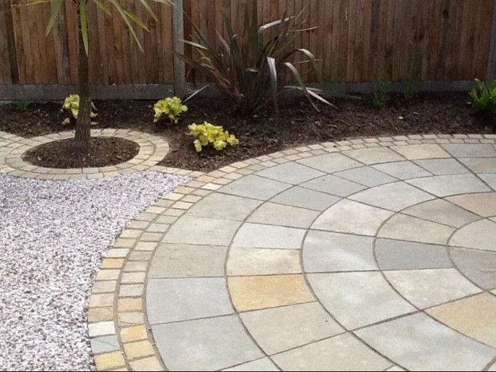A circular patio with a wooden fence in the background