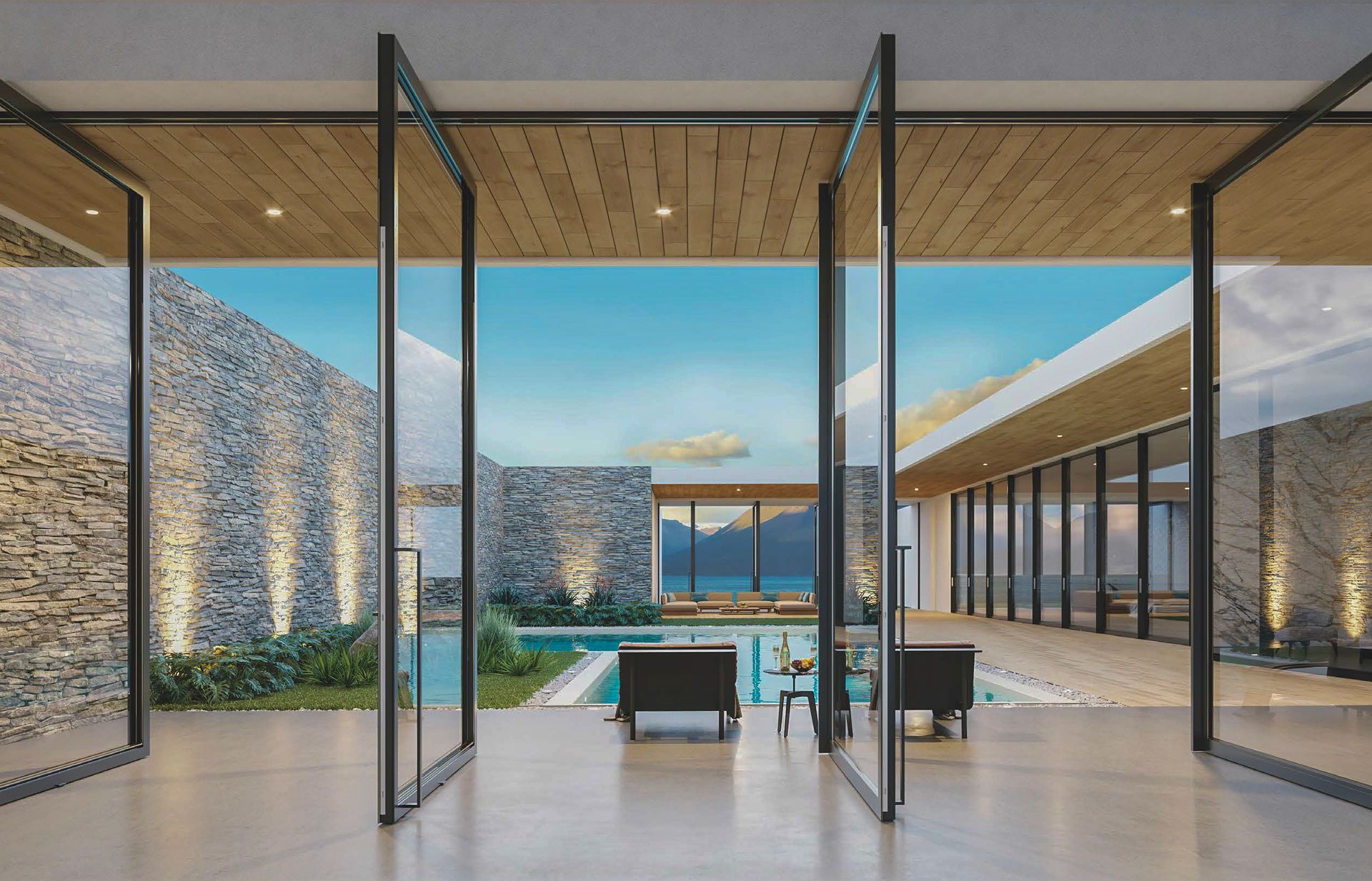 Open glass doors reveal a pool, ocean view, and stone walls. Modern architecture in a bright setting.