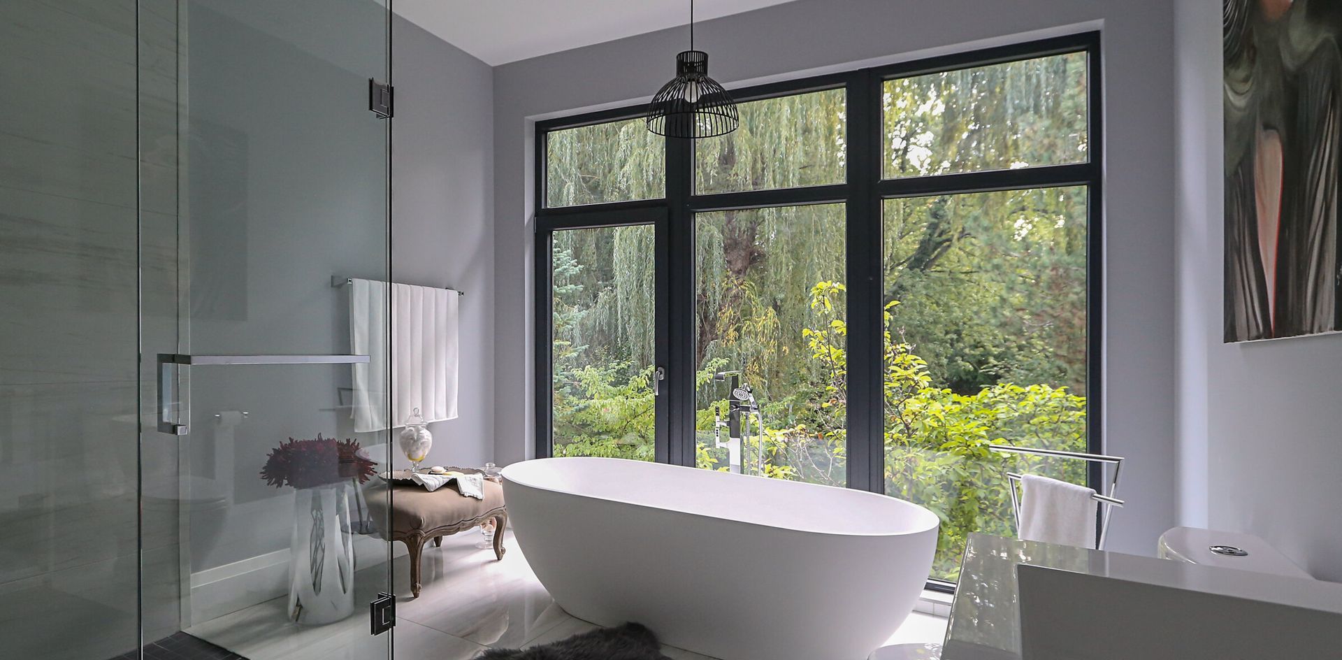 A bathroom with a bathtub , shower , and large windows.