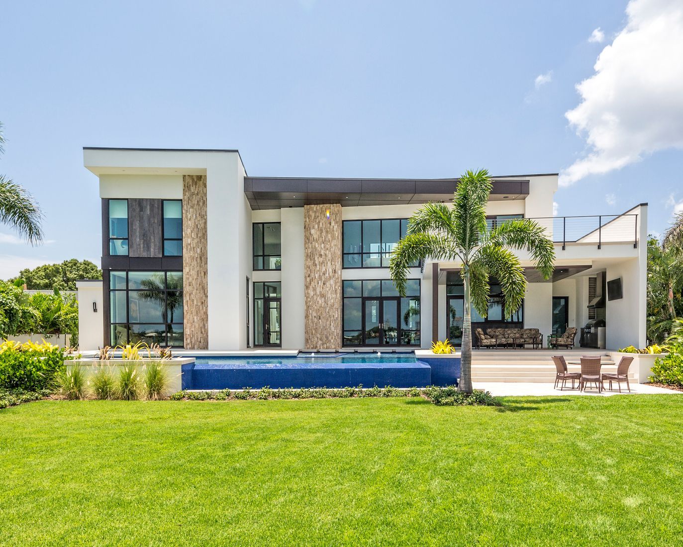 A large white house with a swimming pool in the backyard.