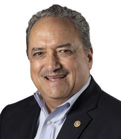 A man in a suit and tie is smiling for the camera. A man in a suit and tie is smiling for the camera.