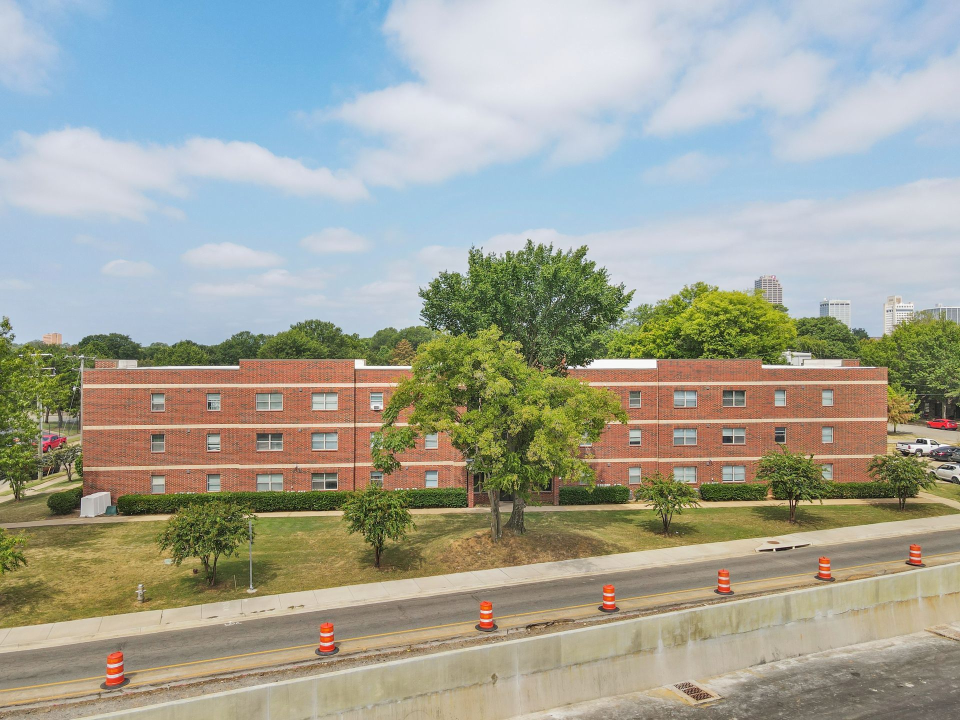A large brick building is sitting next to a highway.
