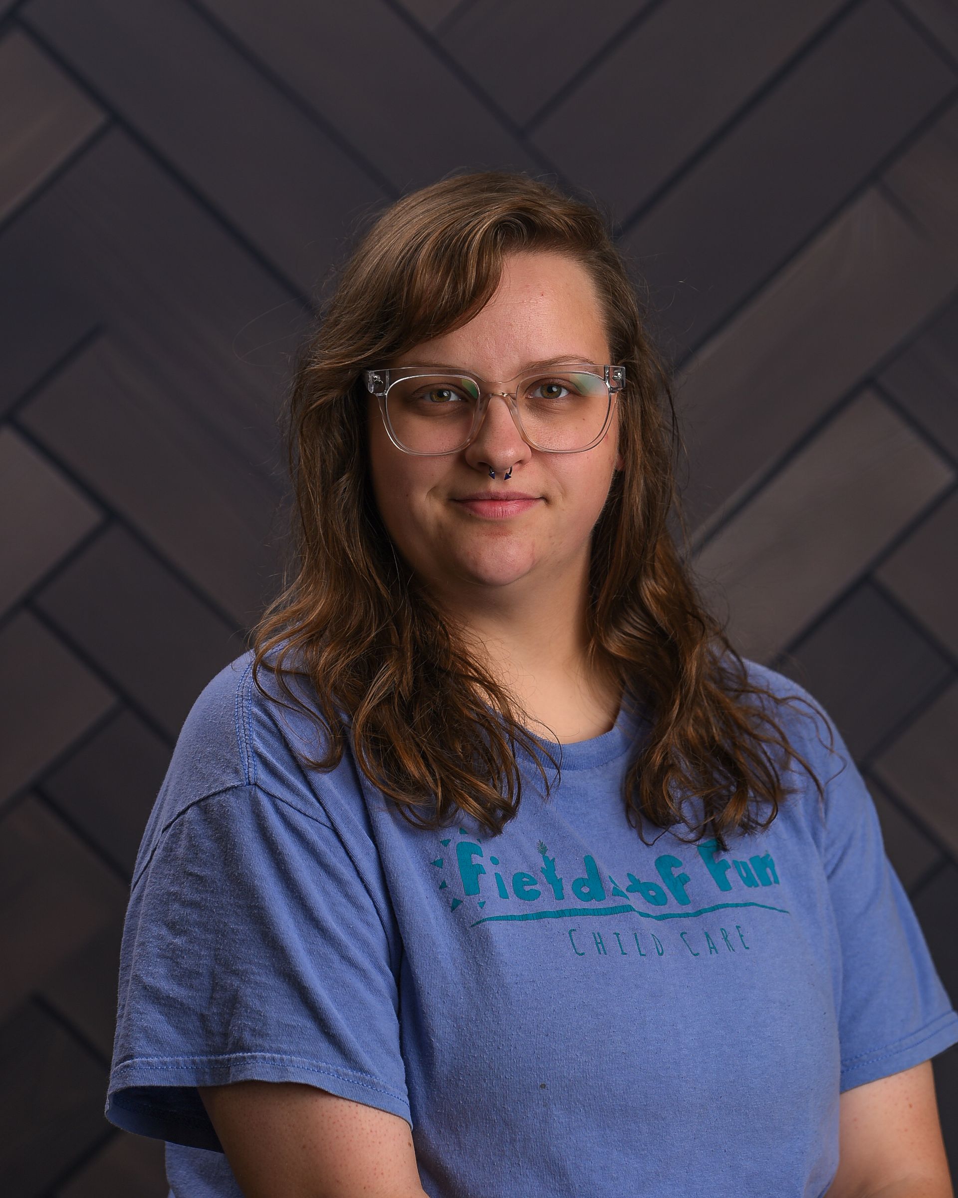 A woman wearing a plaid jacket and a black shirt is smiling for the camera.