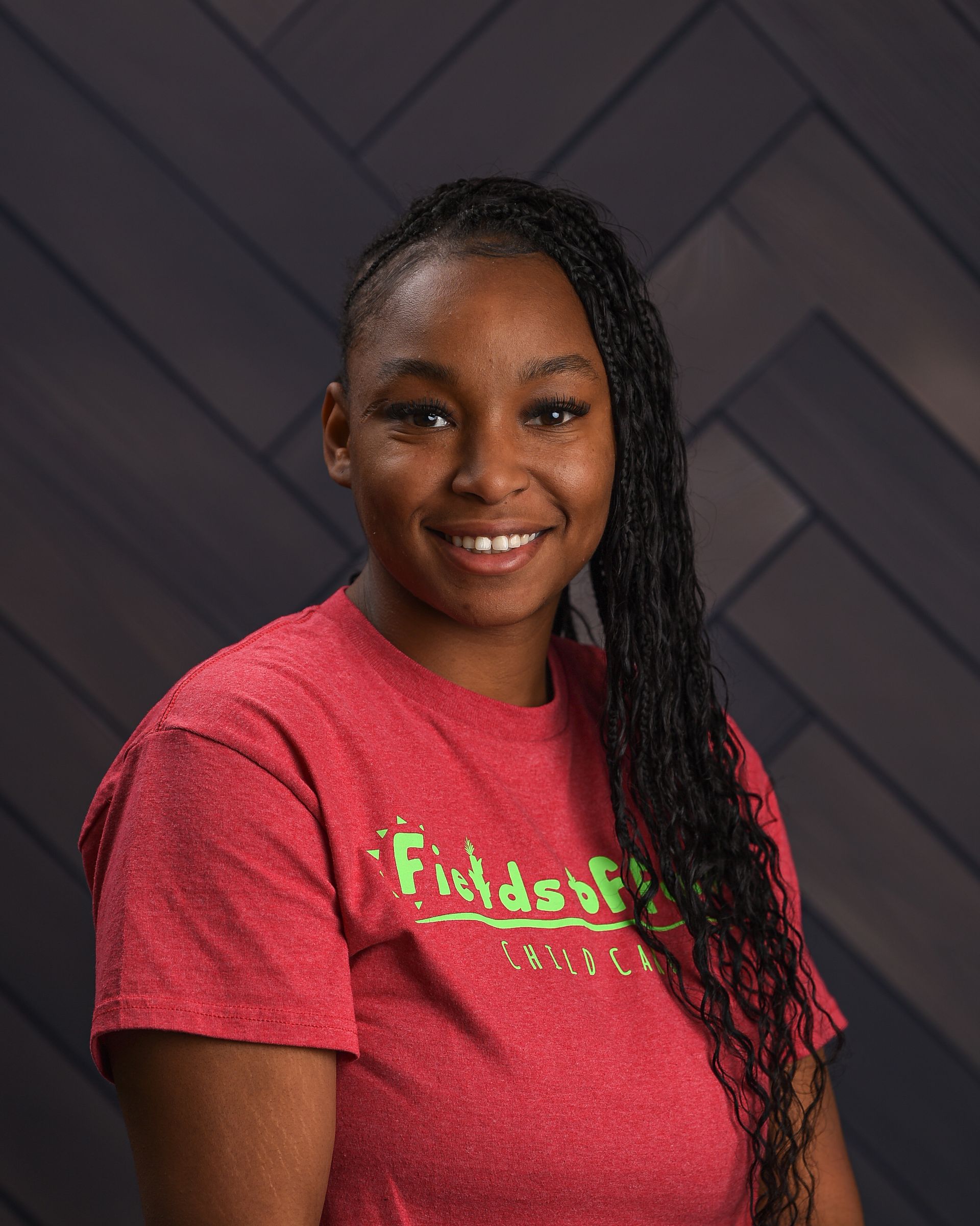 A woman wearing a red t-shirt is smiling for the camera.