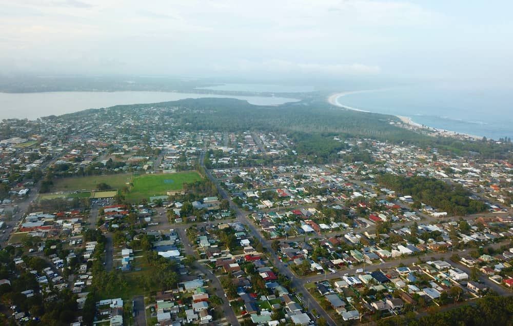 An Aerial View of A City with A Lake in The Background — Pest Control Central Coast in Toukley, NSW