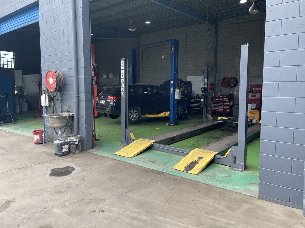 A Car Is Sitting On A Lift In A Garage — Mackay Car & Commercial Pty Ltd In Paget, QLD