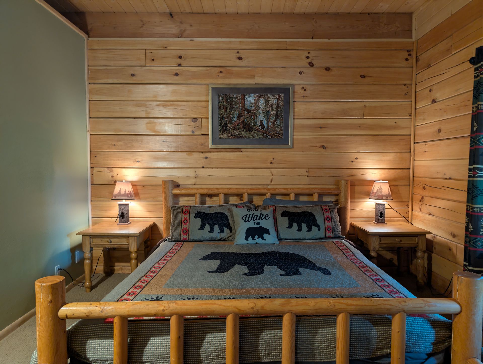 Bedroom with wooden paneling, a log bed, and bear-themed decor.