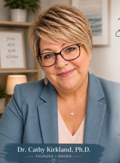 A woman wearing glasses and earrings is smiling for the camera.