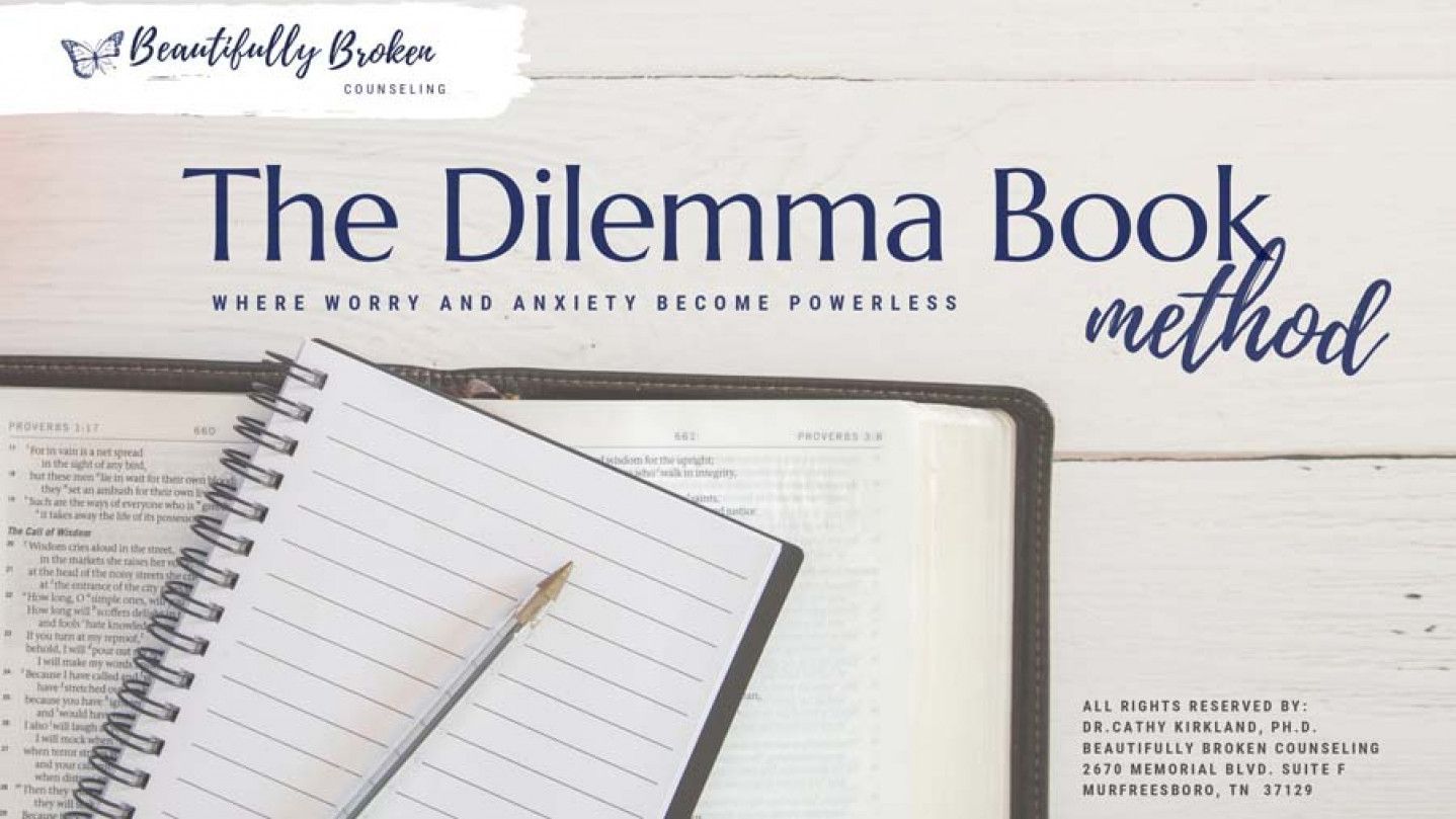 A book titled the dilemma book method with a notebook and pencil