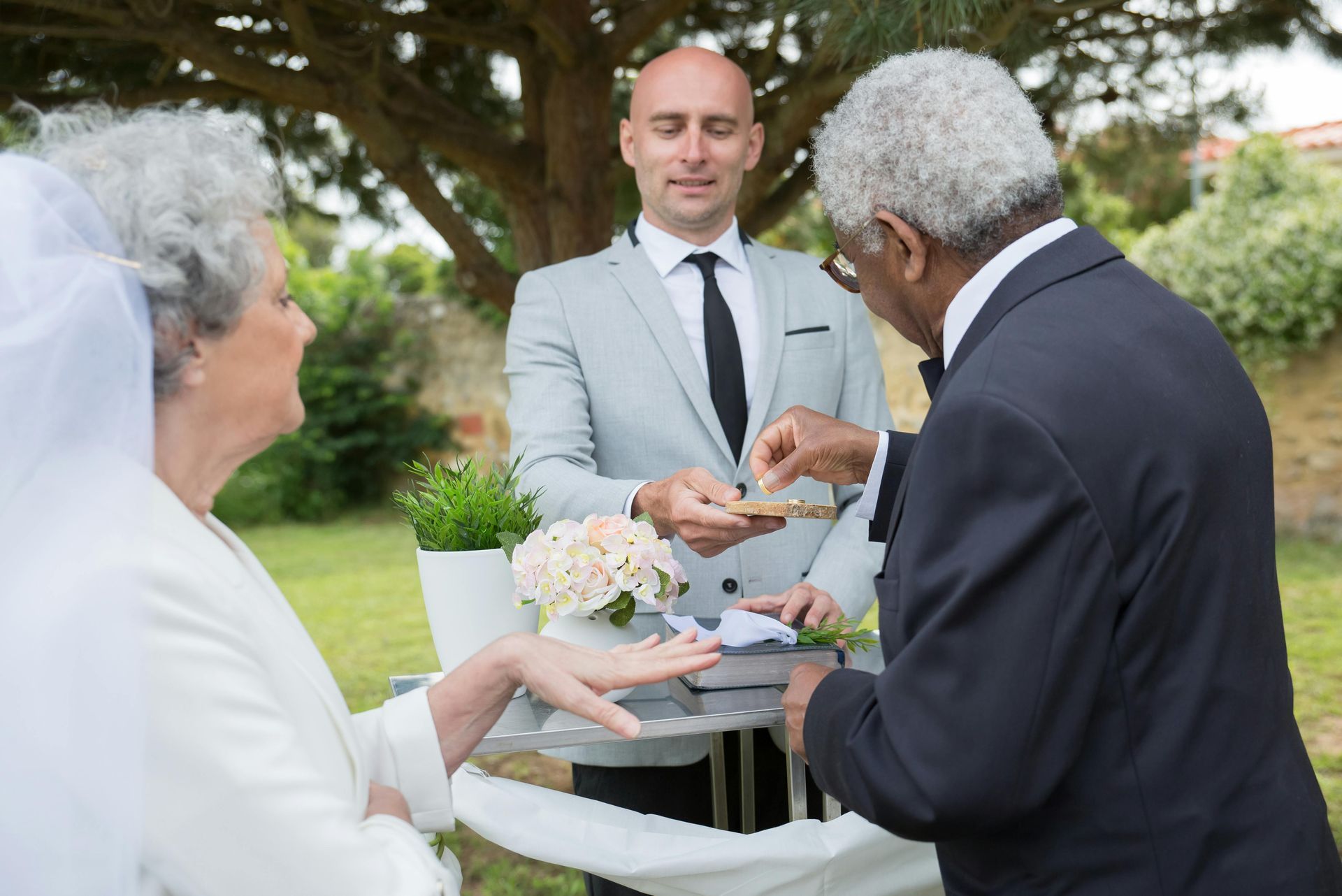 A man in a suit and tie is putting a ring on a woman 's finger.