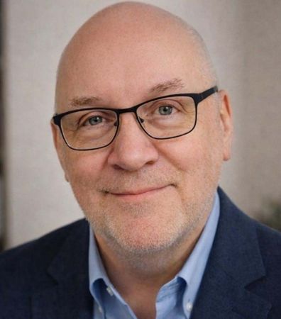 A close up of a man wearing glasses and a beard.