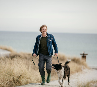 man walking his dog on the beach - allergy relief pets - maryland