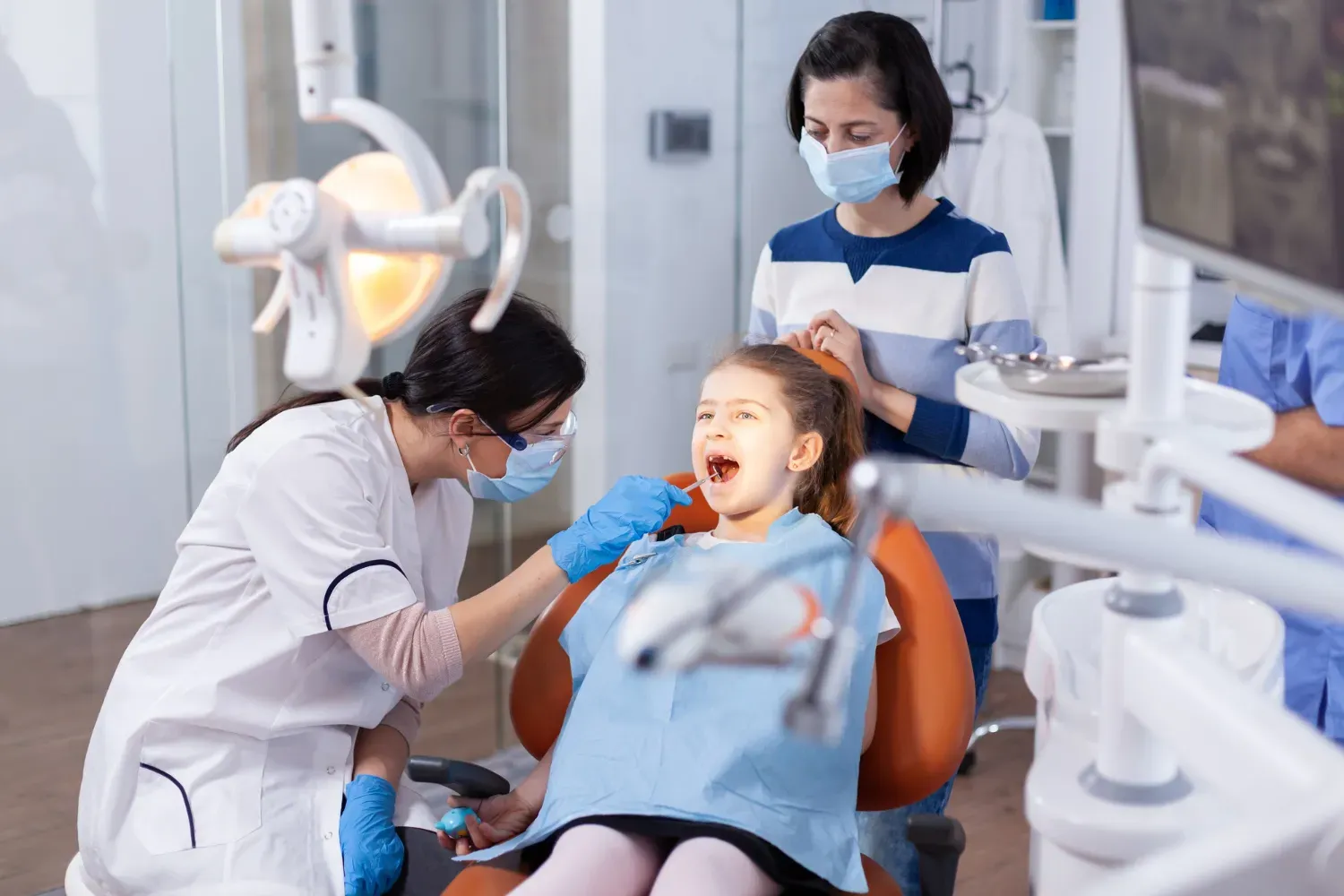 Dentist examining a child in a dental chair