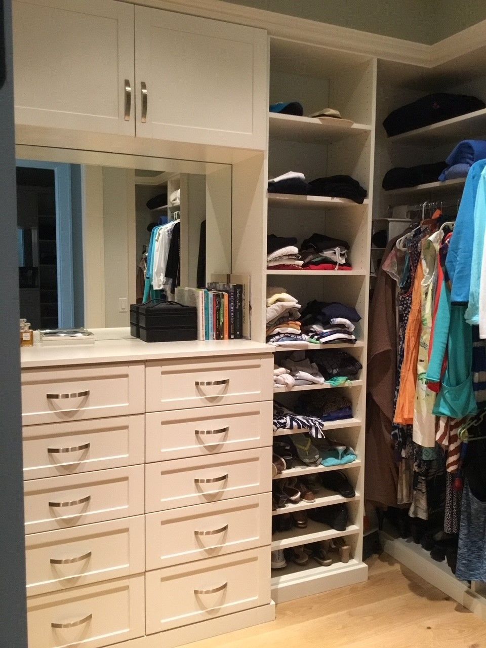 A walk in closet with lots of drawers and shelves