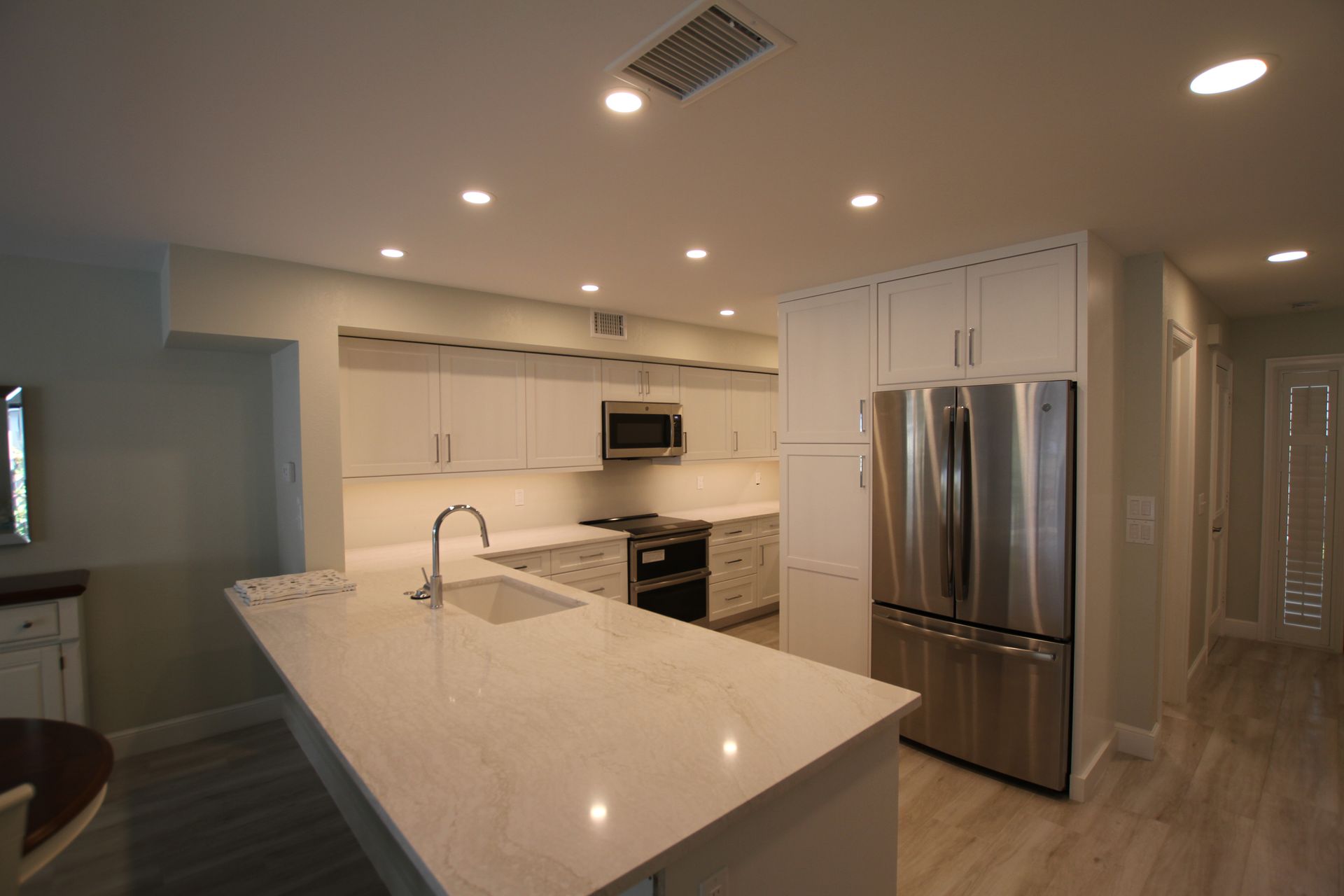 A kitchen with white cabinets and stainless steel appliances.
