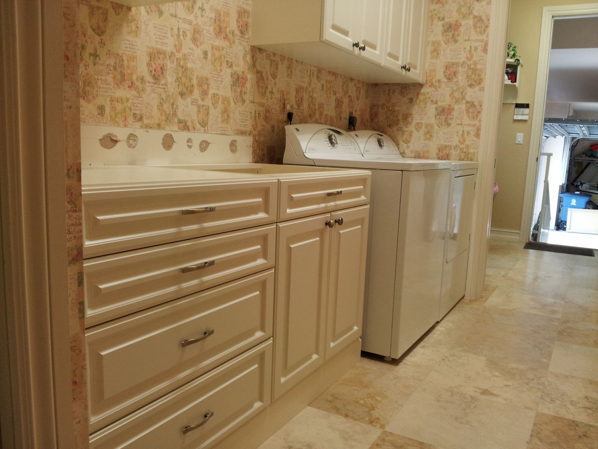 A laundry room with white cabinets and a washer and dryer.