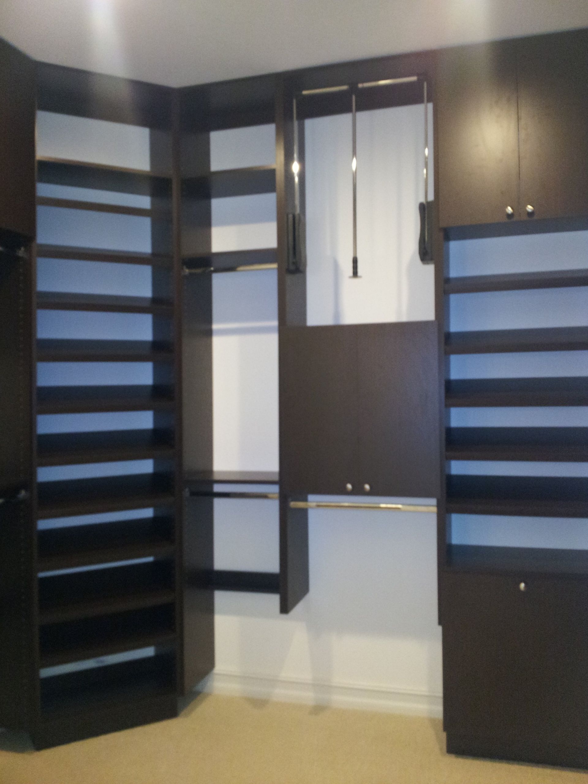 A walk in closet with lots of shelves and cabinets