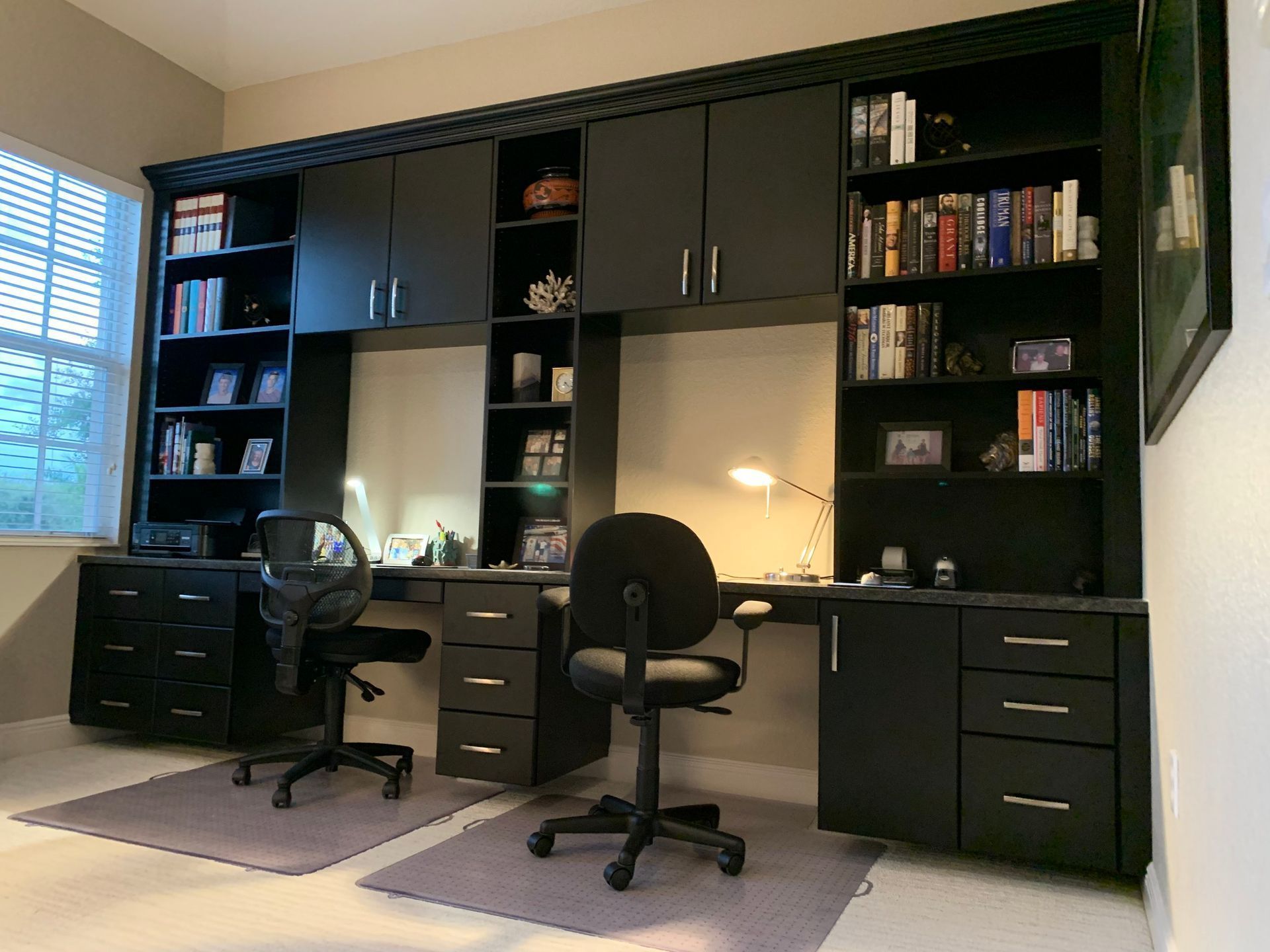 A home office with two desks and a bookshelf