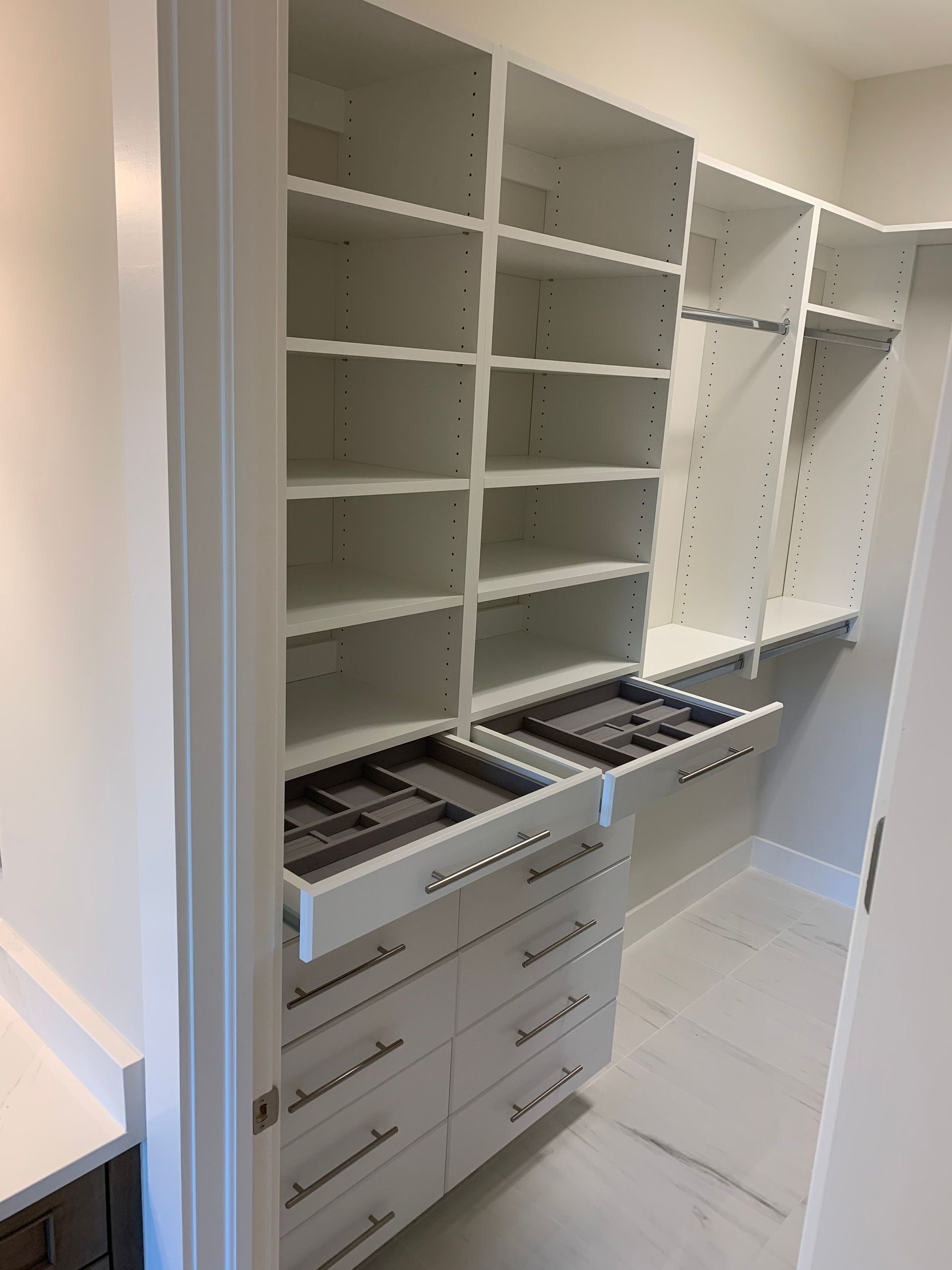 A walk in closet with lots of shelves and drawers.