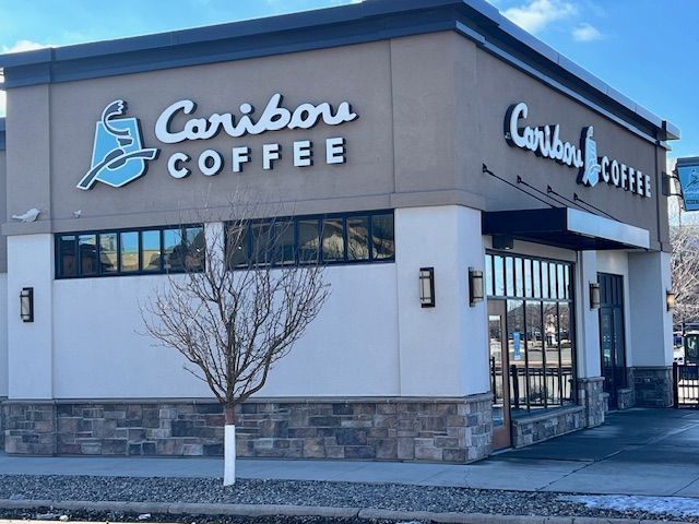 A caribou coffee store with a tree in front of it