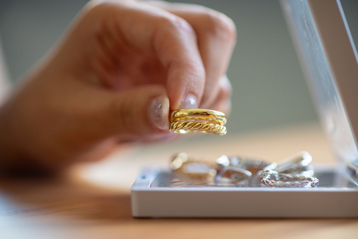 hand placing a golden ring into a jewelry box for moving