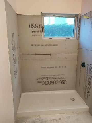 Shower stall under construction with Durock cement board walls and a window.