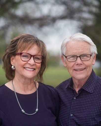 A man and a woman wearing glasses are posing for a picture.