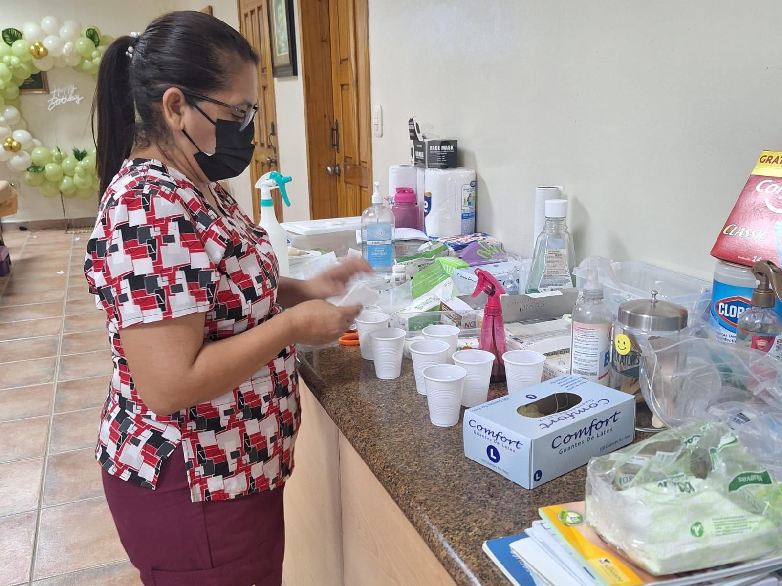 A woman wearing a mask is standing at a counter.