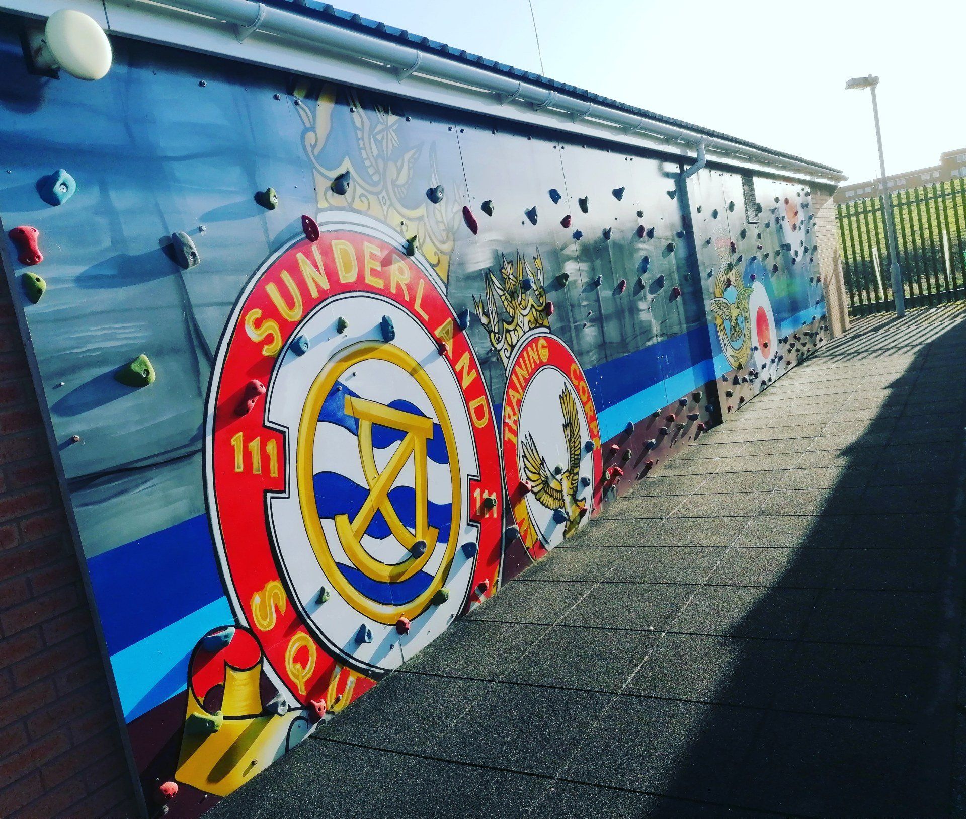 Climbing wall with Sunderland AFC logo on an outdoor paved area.