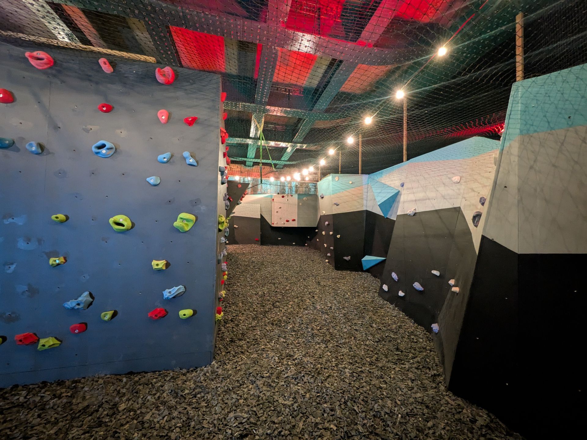 Indoor rock climbing gym with multi-colored walls and climbing holds.