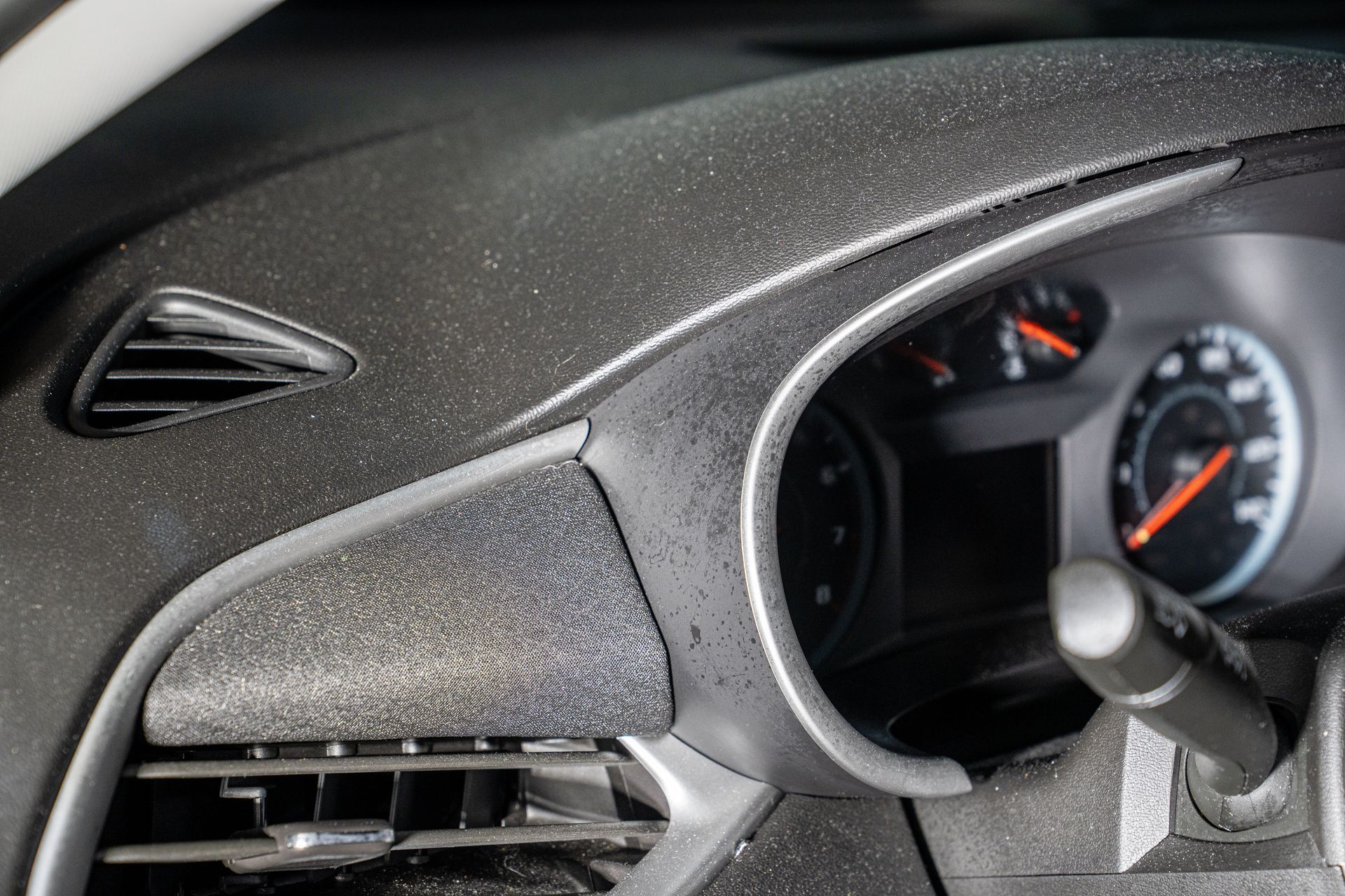 Close-up of a car dashboard with speedometer and textured black interior trim