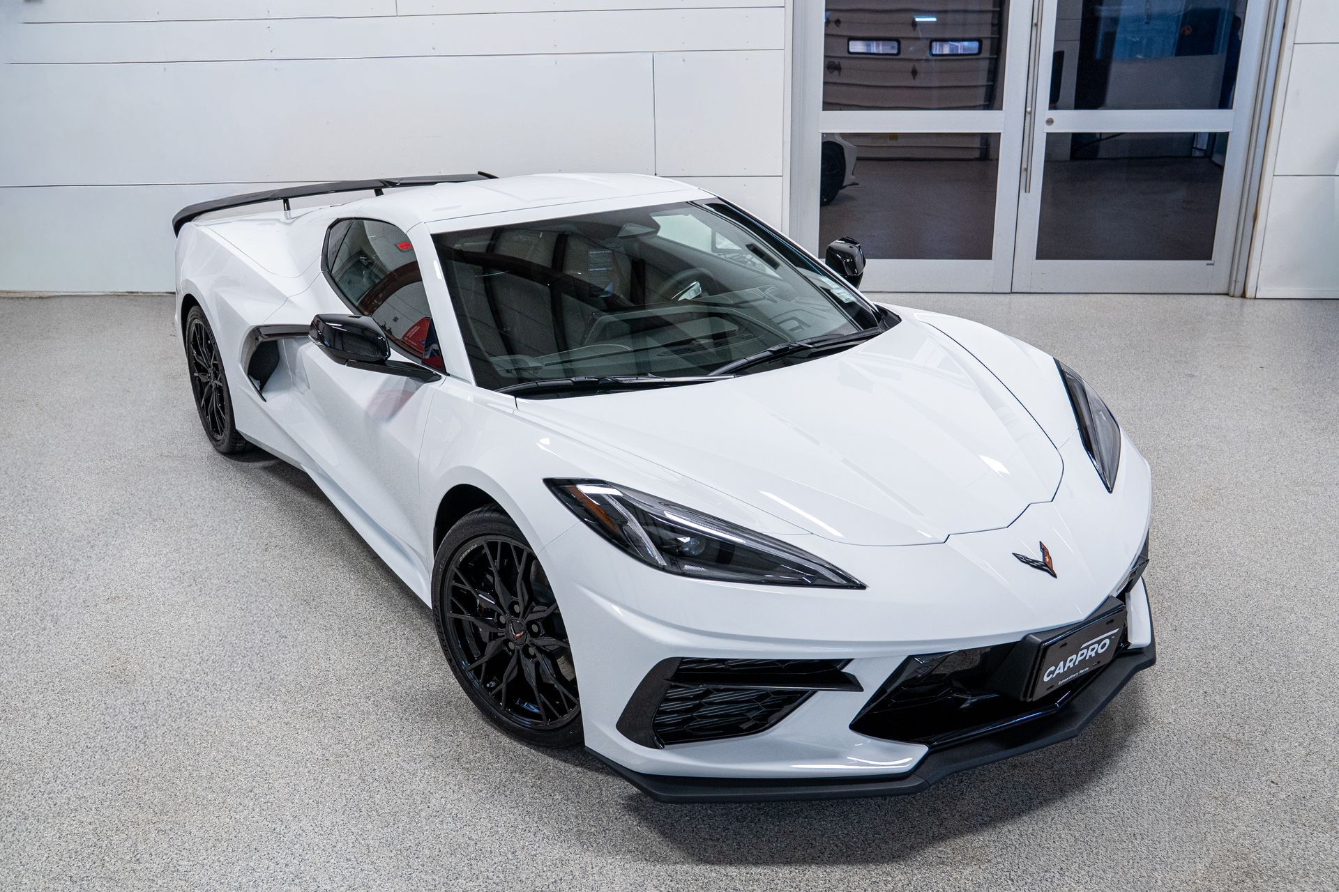 White sports car with black accents parked indoors in a showroom