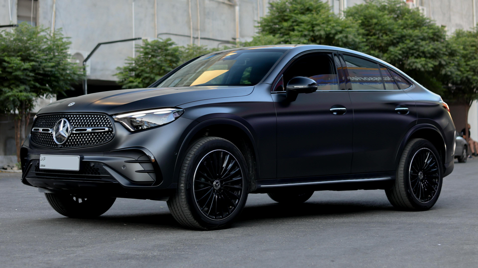 Black Mercedes SUV parked on a street in front of a building