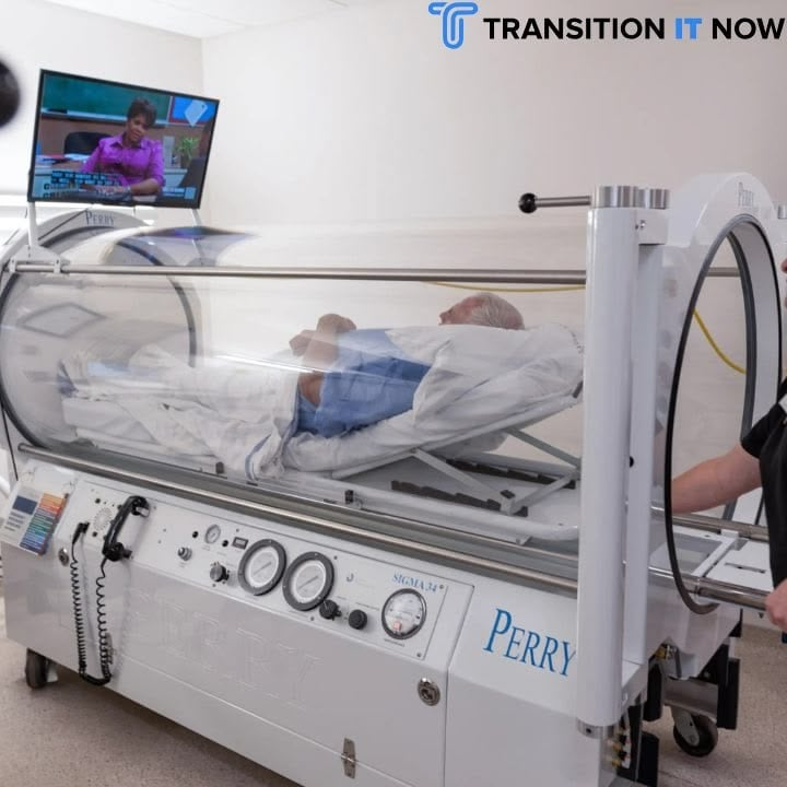 A patient lying in a hyperbaric oxygen therapy chamber while a person adjusts the unit.