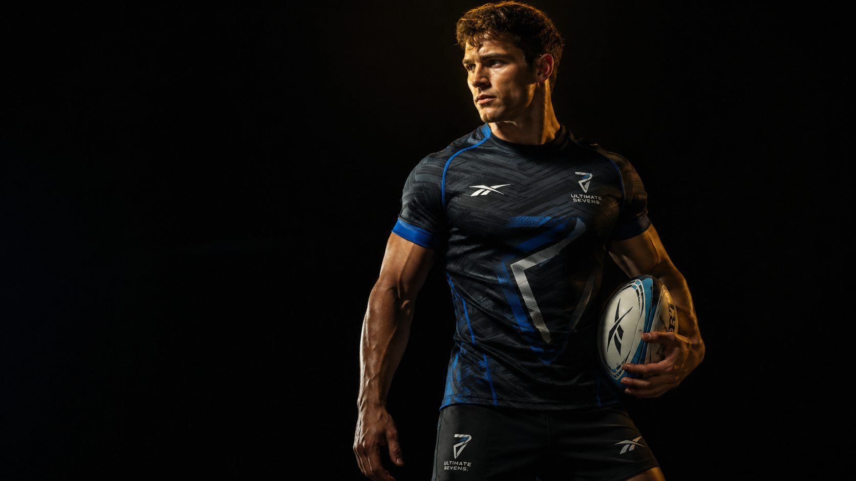 Rugby player in dark blue jersey holding a ball against a black background