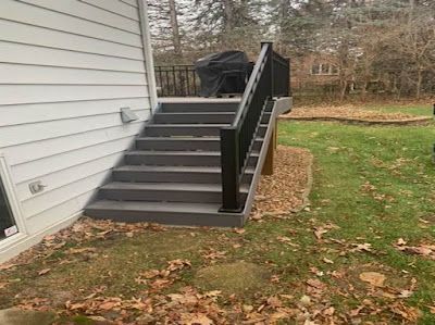 A set of stairs leading up to a deck on the side of a house.