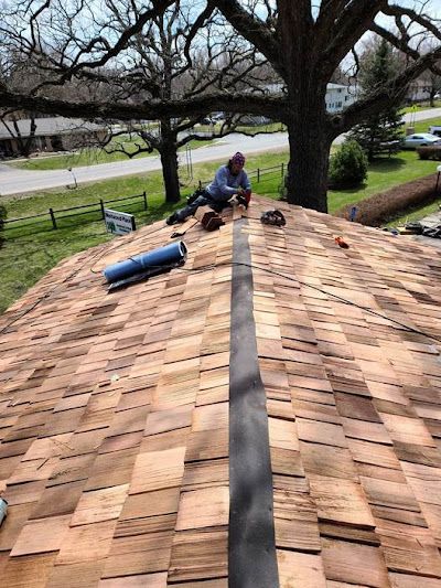 A man is laying on top of a wooden roof.