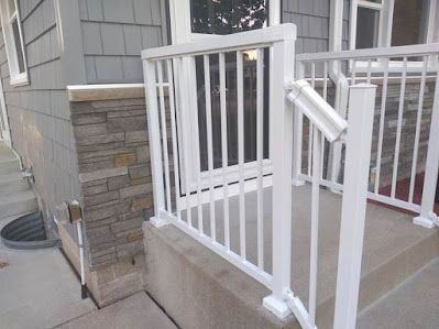 A white railing on the front porch of a house.