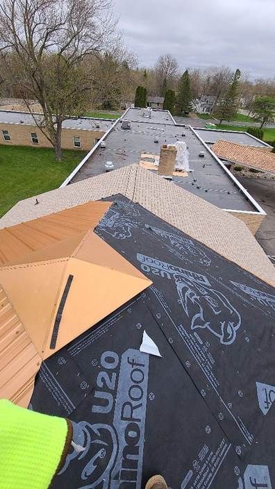 A person is standing on top of a roof.