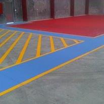 Concrete floor painted with red, blue, and yellow lines, possibly for industrial or safety marking purposes.
